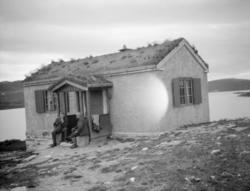 Hytte med to menn på trappa ved Flaksjøen Ringebufjellet.