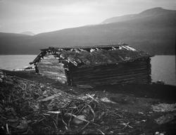 Gammelt naust ved fjellvann.