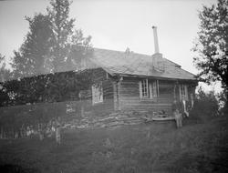 Tømret hytte med 3 voksne og et barn på fjellet. Dobbelekspo