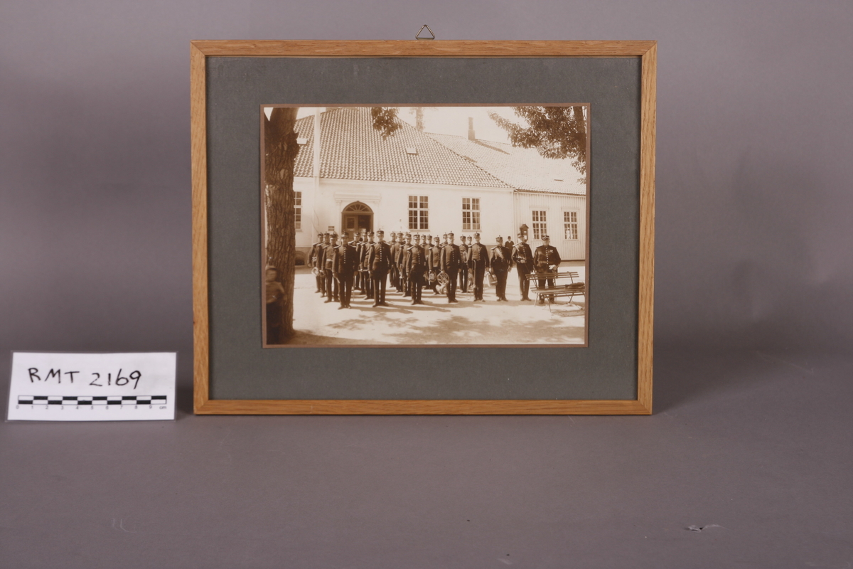 Bildet er av 5.Div Musikkorps i en oppstilling. Bildet tatt etter 1918 (ca 1920) utenfor Kommandantskapets hovedbygning. Munkegata 2, Trondheim.