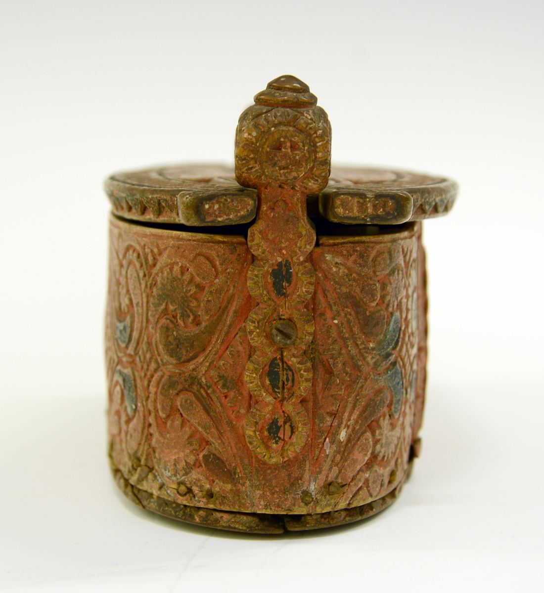 Tine av tre. Fra protokollen: Leikety-tine utskori i grovt kerbsnitt og plymrankkrullar. Under botnen skori 1814 og bokstavar. Standarane løglegt maksla som hovud med haarflettur. Raudmaala.