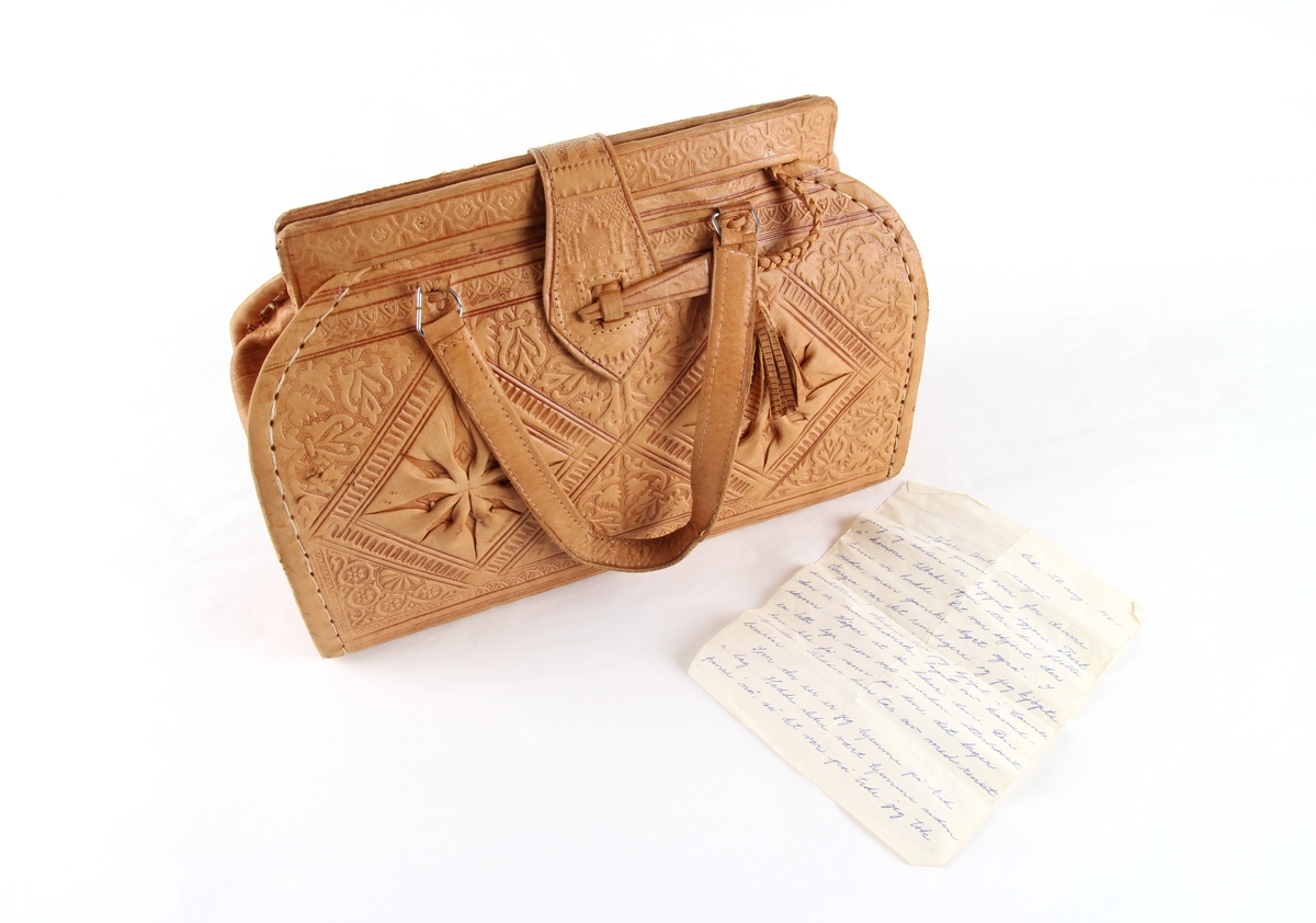 Håndveske i skinn med preget mønster.