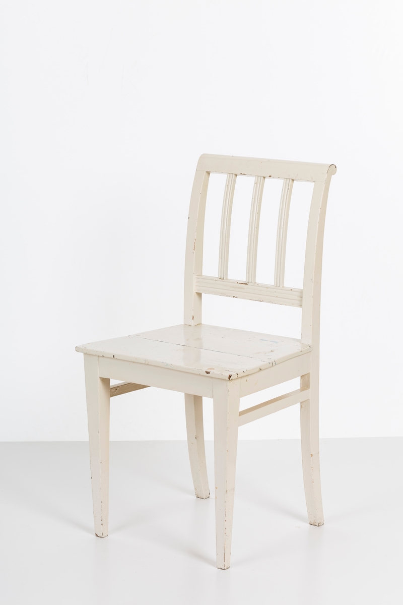 Hvitmalt spisestuestol. Sprosser i rygg og mellom stolbeina på venstre og høyre side.