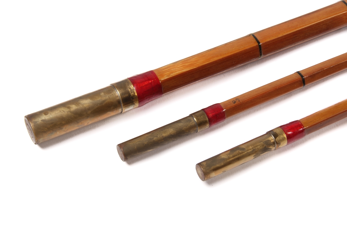 Tredelt fiskestang av type tohands splitcane med ekstra tupp og futeral. Den sekskanta stanga er laga av bambus og handtaket av kork.