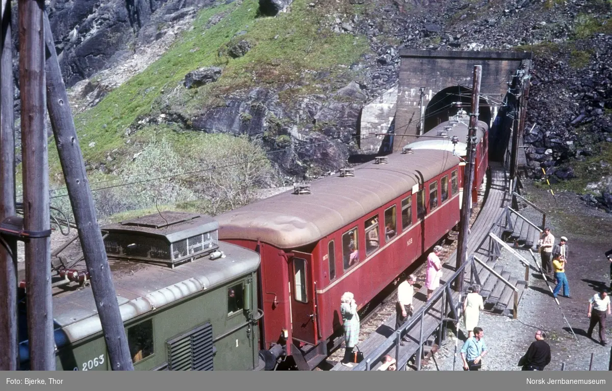 Elektrisk lokomotiv El 9 2063 med persontog 1884 ved Kjosfossen, reisende på plattformen