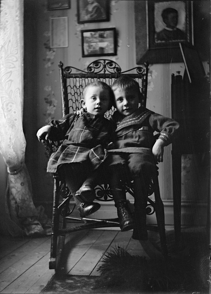 Alf och Roland Liljefors gungar i gungstol i hemmet, möjligen i Göteborg 1906-1907