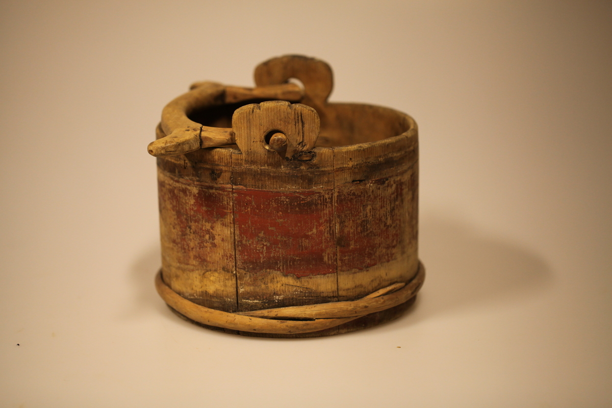 Lagget med 2 gjorder, men den øverste er borte. Bevegelig tverrhank med tretapper, to ører og innfelt bunn. Formen er rund, sylinderformet, uten lokk eller ben. Har vært påmalt rød farge. Brukt til melk.