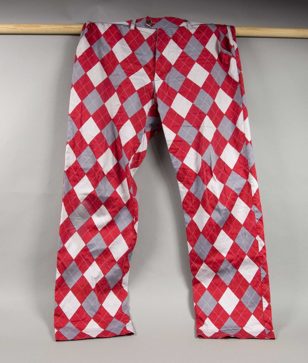 Rød-, hvit- og grårutete bukse.