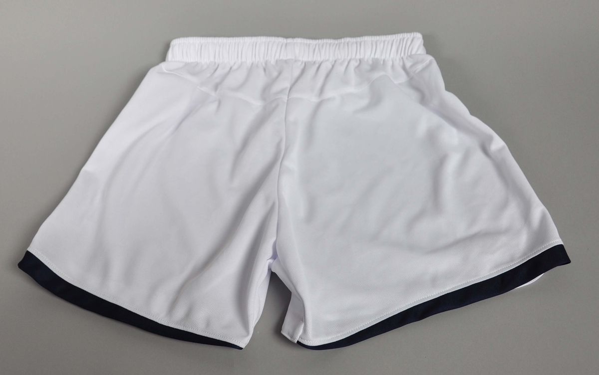 Hvit shorts med mørkeblå kanter,strikk i livet.Umbro-logo påbrodert høyre ben.
Str.:38