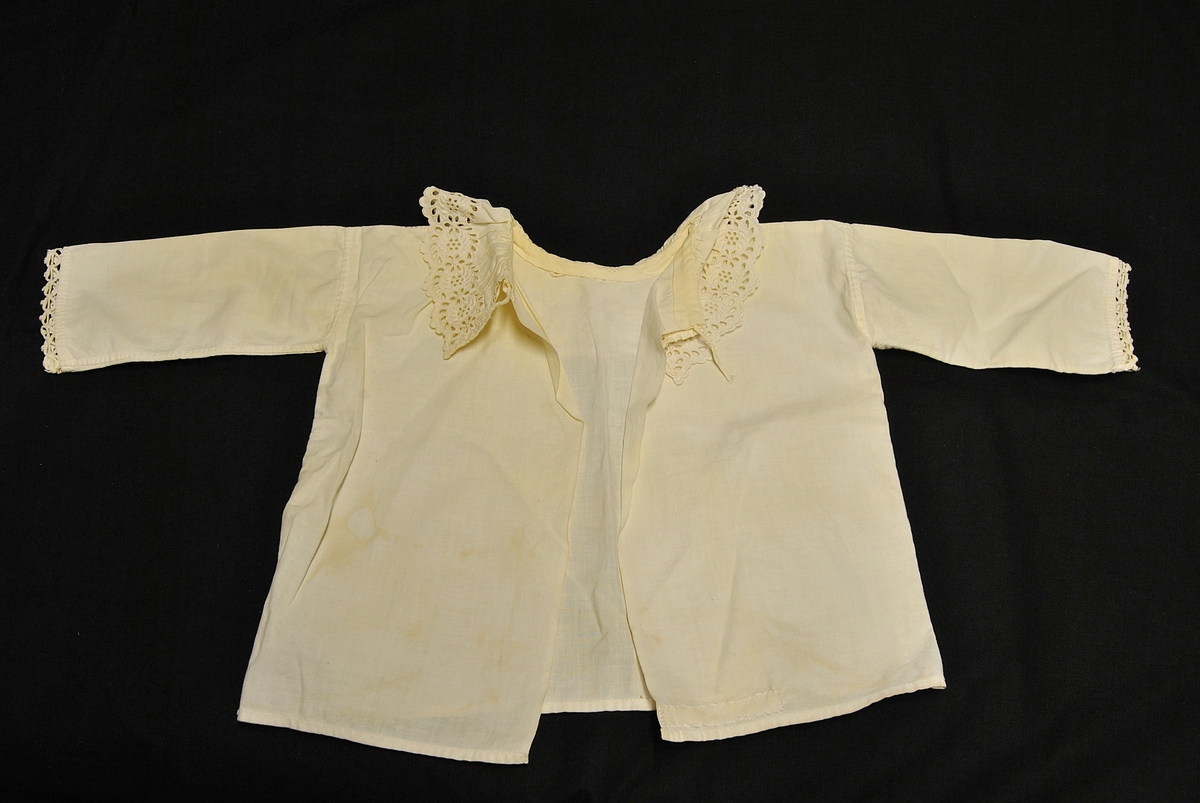 Barnetrøye med blondekrage og nuppereller på ermene. Noe gulnet og flekkete.