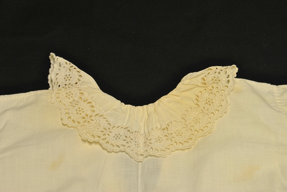 Barnetrøye med blondekrage og nuppereller på ermene. Noe gulnet og flekkete.