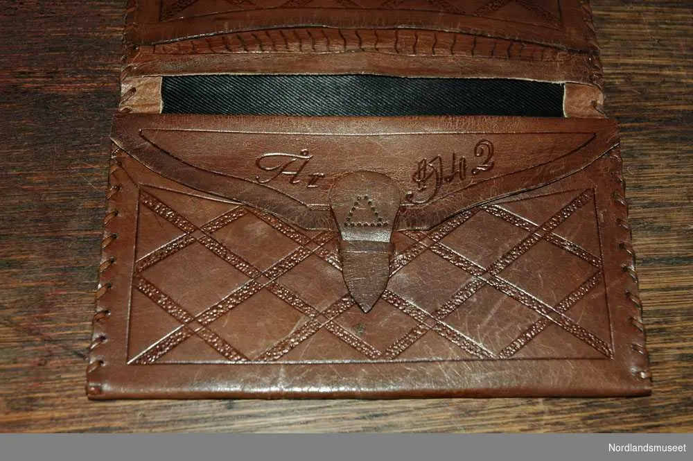 På framsiden av lommeboken har den inginalene "J.B." til Johannes Brateng. Det har også blitt preget inn "År 1942" på innsiden av lommeboken. Lommeboken har 5 lommer og 2 av dem kan lukkes igjen med en liten skinn hempe. Den har et fint mønster av symmetriske firkanter.
