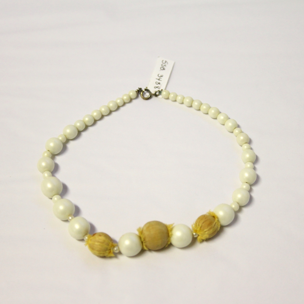 Halskjede/-smykke av imiterte perler og små frukter: plommer og pærer.