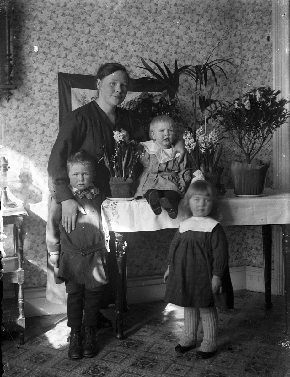 Kvinna med tre små barn.