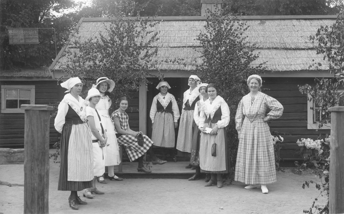 Motiv från firandet av Barnens Dag i Linköping 1925. Platsen är skolgården till Linnéskolan som för firandet rustas med miljöer och attraktioner. Bilden visar den tillfälliga gästgivaregården med personal som var ett av många inslag.