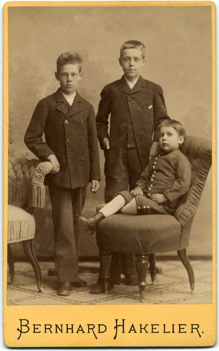 Kabinettsfotografi: tre okända pojkar, den yngsta sittande i en fåtölj. En syskongrupp?