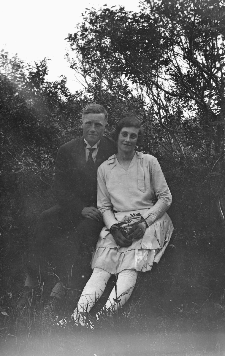 Mann og kvinne sittende i gresset.