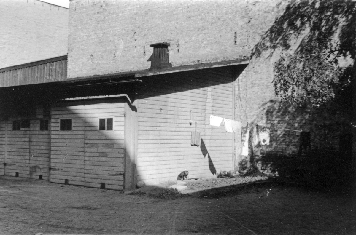 Gårdsinteriör från kvarteret Tunnan i Norrköping. Bilden visar uthuslänga tillhörande Repslagaregatan 23. Fotografiet är taget i samband med rivningsansökan 1953.  Vy mot nord.