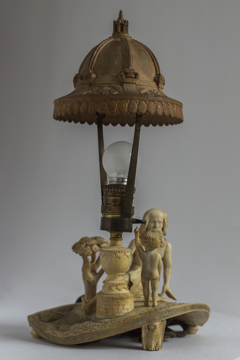 Lampefot i horn. Motiv av barn som spør sin far om lyset-miniatyrlandskap. Lampeskjerm i tre formet som en kuppel med lanterne i toppen. Søyle og akantusdekor.