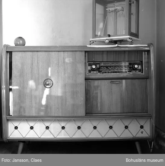 Enligt uppgift: "Radiogrammofon med barskåp inköpt (begagnad) 1965. Ovanpå radion en laboratorievåg som tidigare användes i vågrummet".