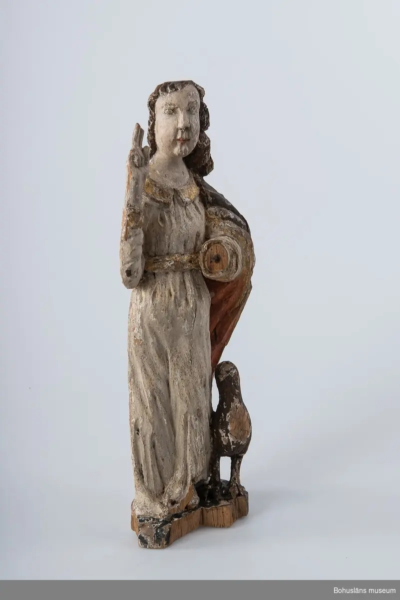 Skulptur, apostelbild från 1600-talet som tillhör altartavla UM000393.
Krederat trä med mager oljefärg och oljeförgyllning. Förgyllningen uppvisar båda bladguld, slagmetall och/eller silver.

Ur handskrivna katalogen 1957-1958:
Apostelbild, Lane Ryr 
H. 40 cm; Kristus, höger hand höjd t. välsignande åtbörd, vänster bär ett klot; färgen delvis flagn; sprickor.
Krederat trä med mager oljefärg och oljeförgyllning. Förgyllningen uppvisar båda bladguld, slagmetall och/eller silver.
Lappkatalog: 13

Se foto på föremålet i Uddevalla museums kyrkliga utställning 1920, UMFA54467:0422.

Ytterligare en kyrklig skulptur är märkt med inventarienummer UM394, aposteln Johannes med välsignelsegest och en örn, manteln är har rödmålad insida. Denna skulptur återfinns emellertid inte på äldre bilder av altartavla UM000393, den äldsta fotot UMFA916 samt ett yngre fotografi, UMFA917 som är taget i kyrkliga utställningen av Maria Lundbäck, och alltså inte kan vara senare än år 1927.

Ur Nationalencyklopedin, NE.se:  Apostel
I konsten framställs apostlarna alltid barfota samt klädda i tunika och mantel. De bär oftast en bok samt sitt individuella attribut, i allmänhet respektive martyrredskap (Petrus bär dock himmelrikets nycklar).