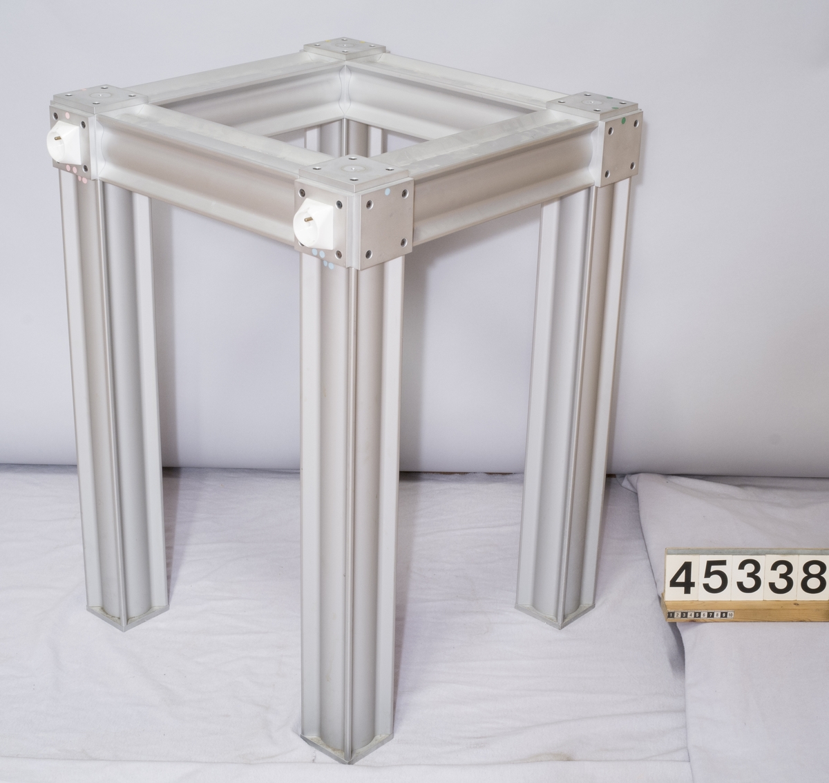 Laboratoriebord med bordskiva av marmor med benställning av aluminiumprofiler. I benställningen finns två eluttag och en anslutning för apparatsladd.