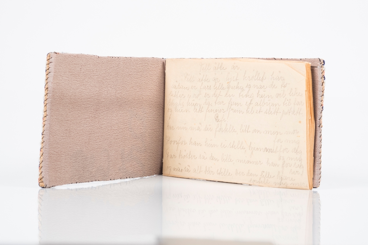 Sangbok/ minnebok med korsstingbrodert for- og bakside. På forsiden blomster i flere farger, på baksiden teksten:
"9326
GRINI
1943-45"