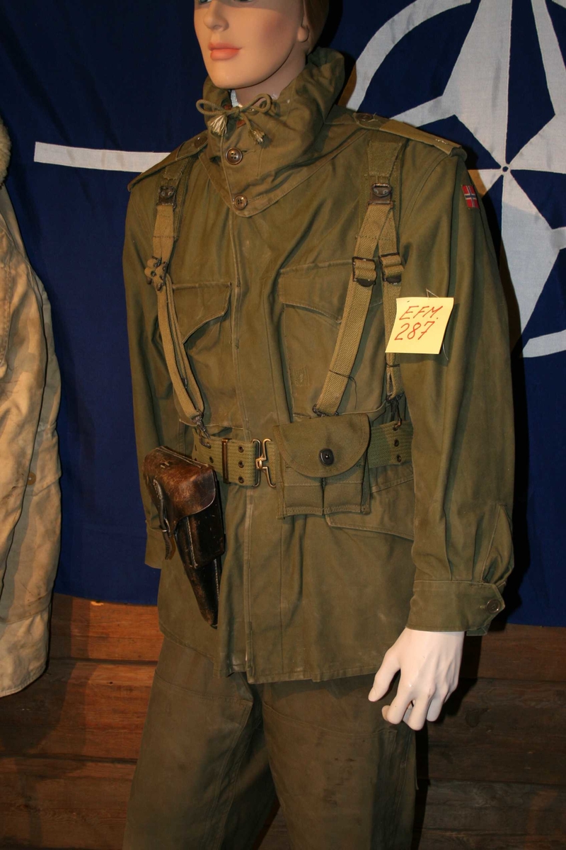 Uniformen består av bukse og jakke med hette. Jakke har knepping forran og rundt håndledd. 4 lommer forran og skulderklaffer med distingsjoner.