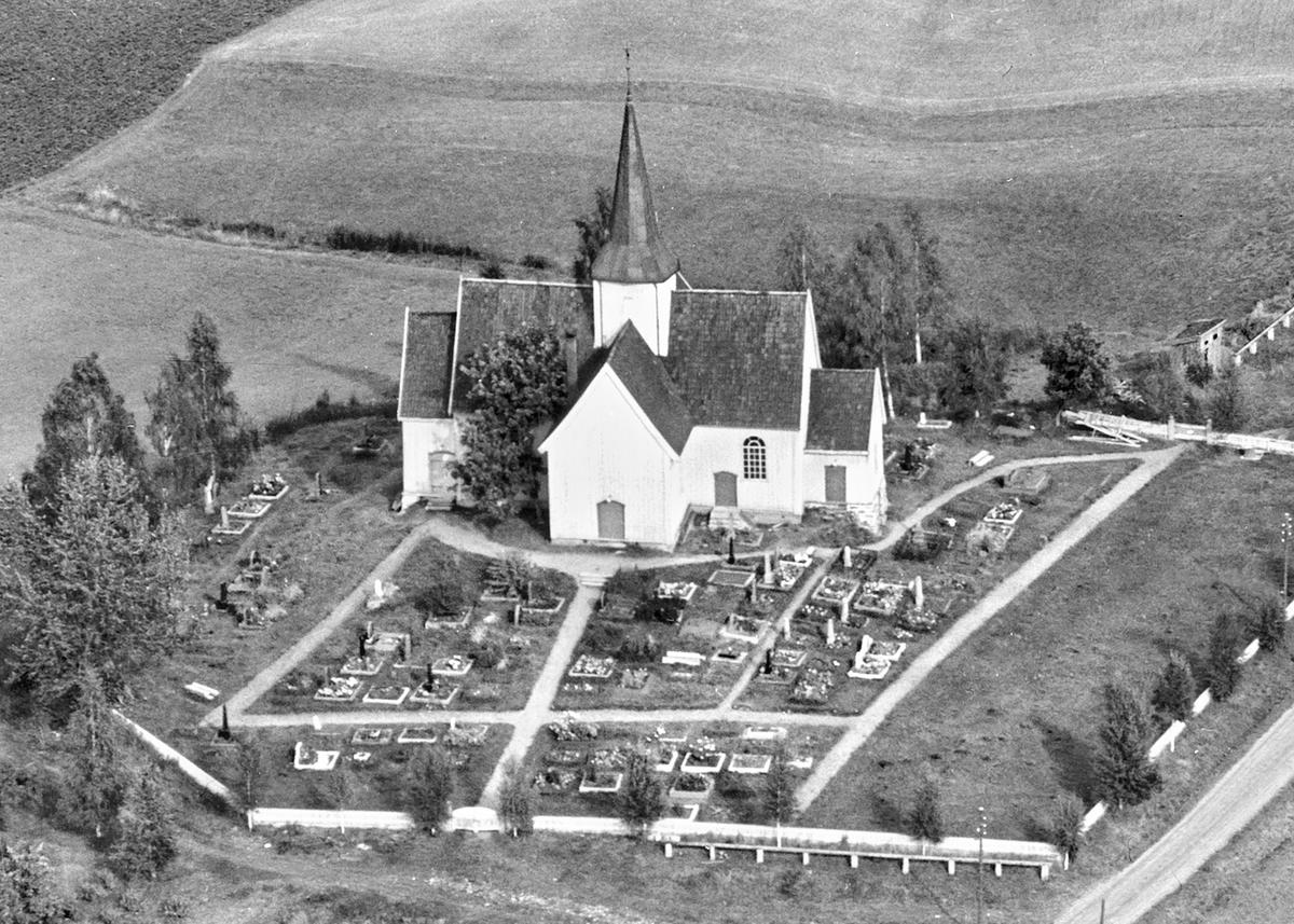 Svart-hvit foto tatt fra luften av en hvit kirke.