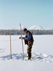 Osvald Kolbu fanger lake med fiskesaks på den snødekte isen 
