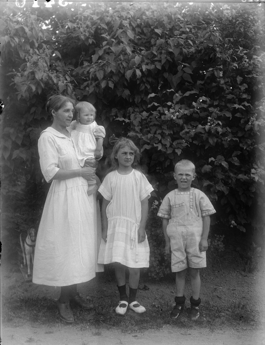 "Fru Maja Thelin Hässelby gård Uppsala med barnen" i trädgården i Fröslunda, Altuna socken, Uppland 1923