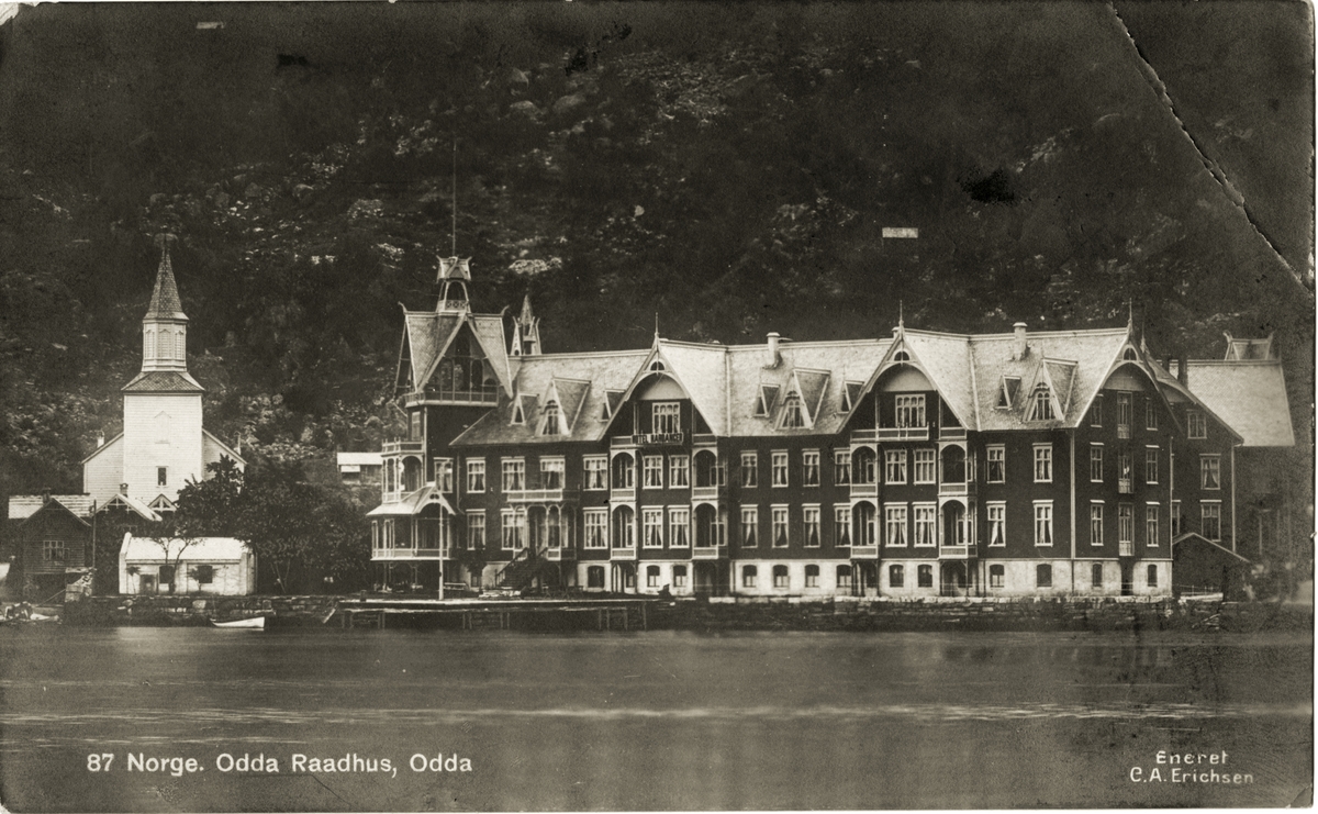 Postkort som viser Odda rådhus, tidl. Hotel Hardanger, Gurinakaien og Odda kyrkje.