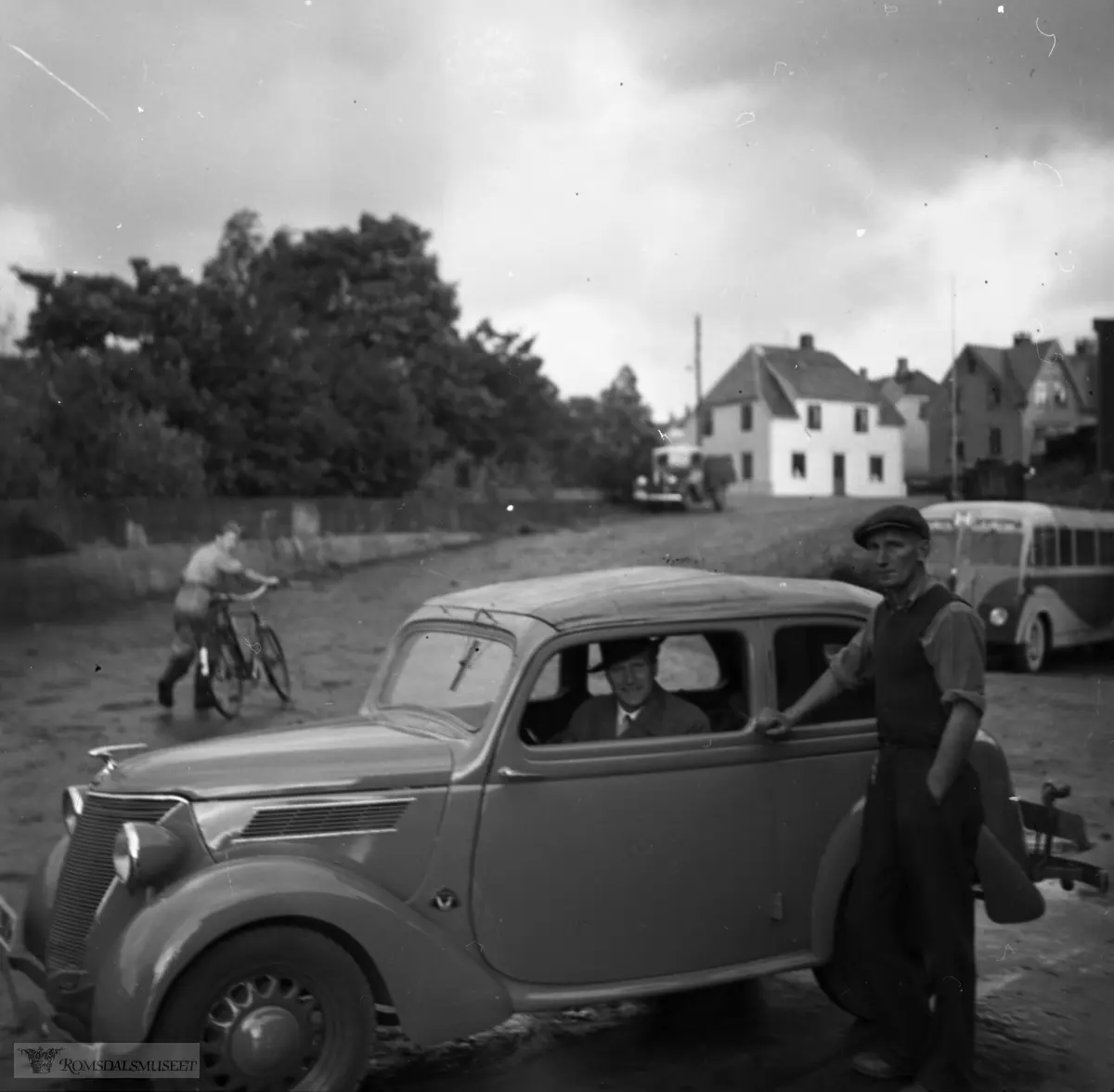 På oversiden av Ford-forandler Haukebø og Rødseth sitt bygg i Romsdalsgata..Bilen er en tyskbygd Ford Eifel cabriocoach (stofftak men faste siderammer rundt vinduene) årsmodell 1937-38.