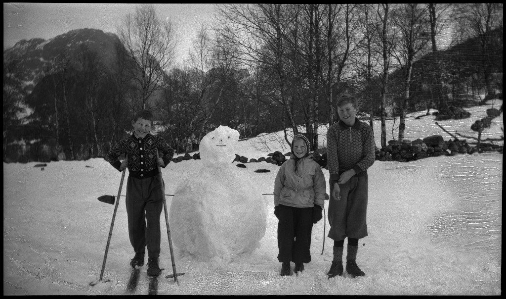 Tre unge menn på skitur i Madlandshei. Det er også bilde av noen barn som har bygd en snømann.