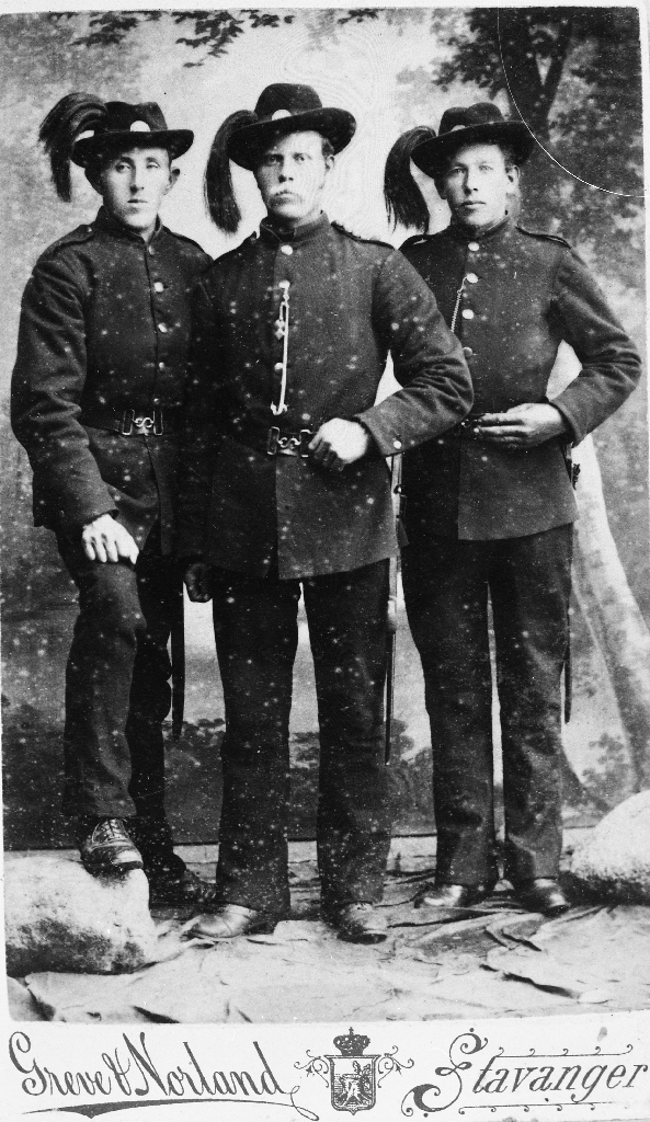 Tre ukjende personer i gardeuniform.