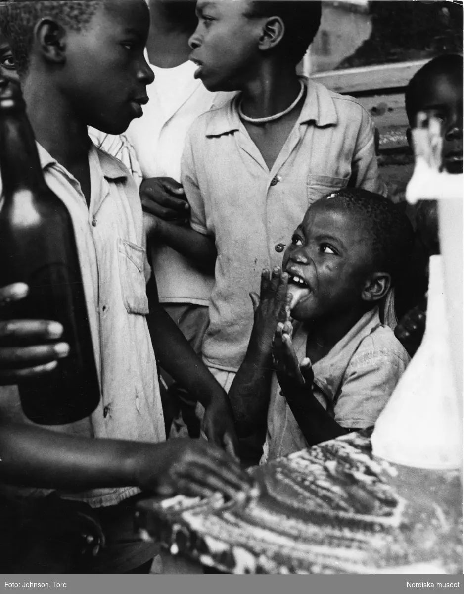 Biståndsverksamhet, Kongo. Barn får mjölk, som de skrapar upp från ett bord.