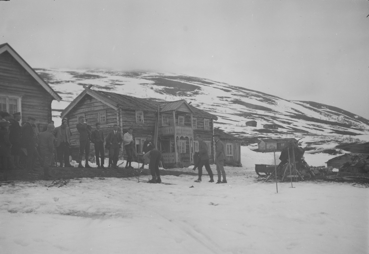 Sjodalen, Bessheim med gruppe mannfolk med utstyr og ski ved inngangen. Lite snø