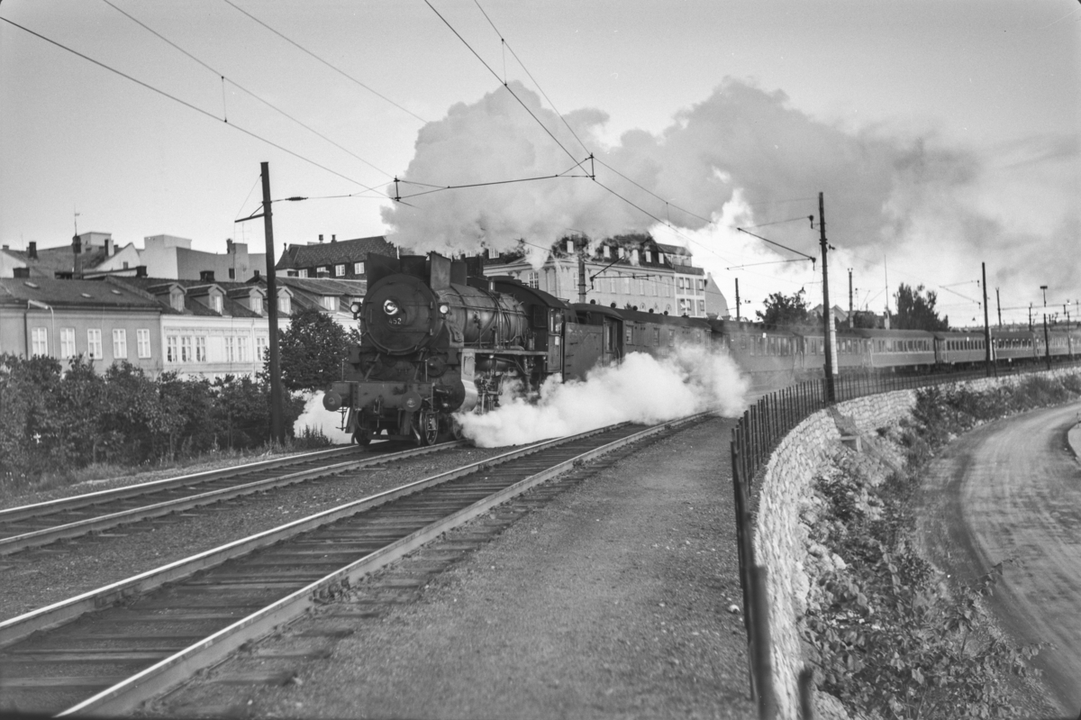 Persontog fra Oslo Ø til Otta, Pt. 307 kjører ut fra Hamar stasjon. Toget trekkes av damplokomotiv type 31b nr. 452..