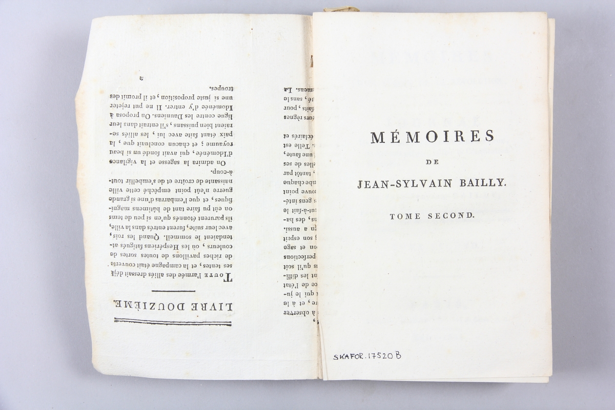 Bok, pappband, "Mémoires de Jean-Sylvain Bailly", del 2, tryckt 1804 i Paris. Pärmar av gråblått papper, blekt rygg med tryckta etiketter. Klistrade sidor ur annan bok på pärmarnas insidor. Skuret snitt.