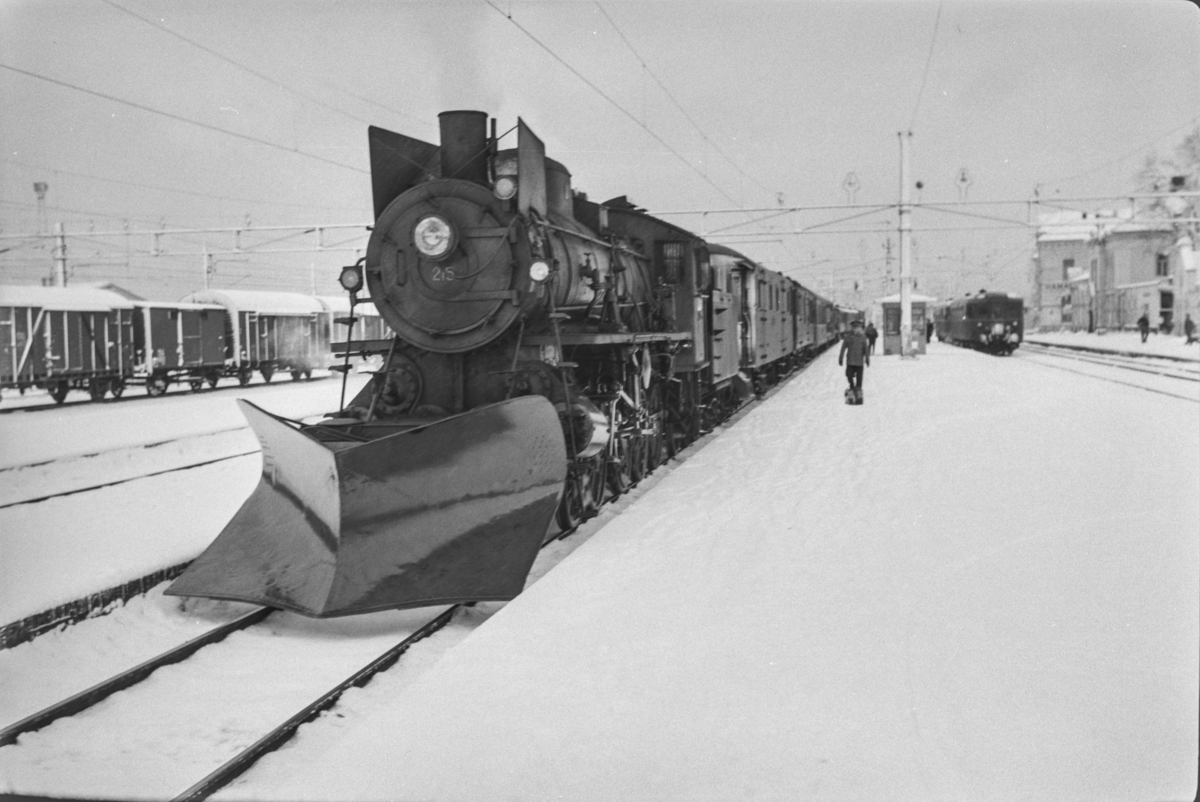 Persontog fra Oslo Ø til Trondheim over Røros, Pt. 301, på Hamar stasjon. Toget trekkes av damplokomotiv type 26a nr. 215.