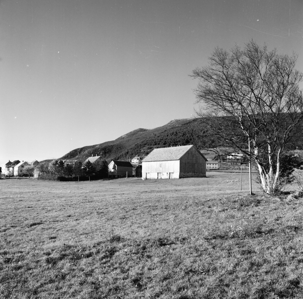 Prospektfotografi av et gårdstun med løa i forgrunnen på Valderøya.