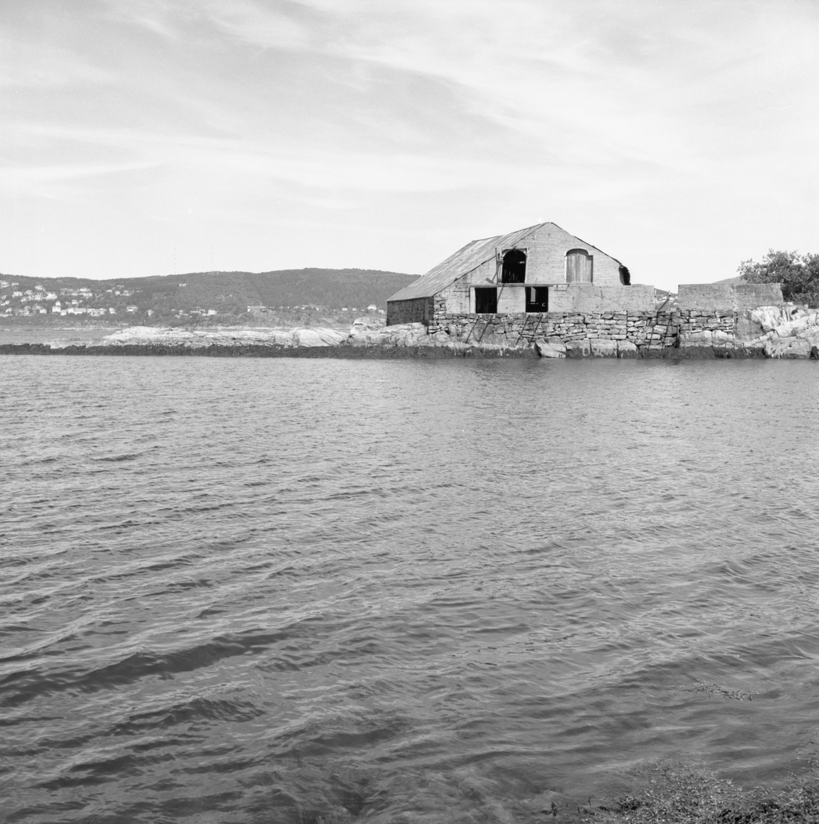 Prospektfotografi av ei gammel driftsbygning ved sjøen på Sula.