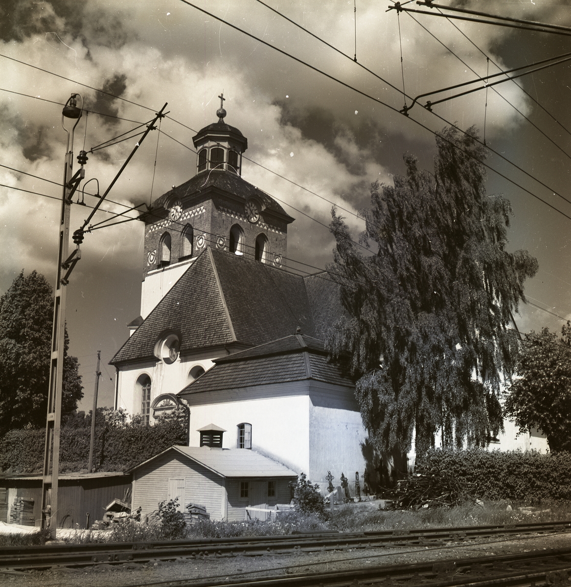 Bollnäs kyrka bakom ett järnvägsspår.