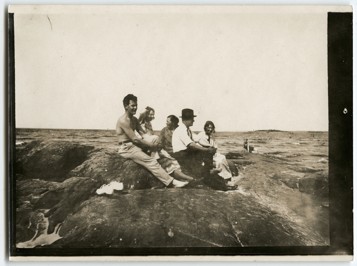 Grupp med människor som sitter på en klippa