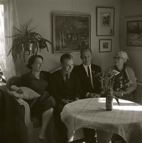Två kvinnor och två män sitter i en soffa vid en bord, 1964.