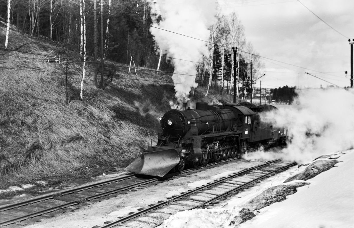 Godstog til Bergen, tog 5505B, kjører ut fra Hønefoss stasjon. Toget trekkes av damplokomotiv type 31b nr. 453