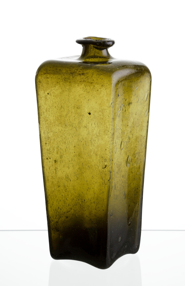 Ginflaska.
Tillverkad under andra halvan av 1700-talet.
Fyrkantig, avsmalnande nedåt. Formen var ursprungligen anpassad efter de fraktlådor man hade med sig på fartygen. Tack vare formen stod flaskorna stadigt trots hårt väder.