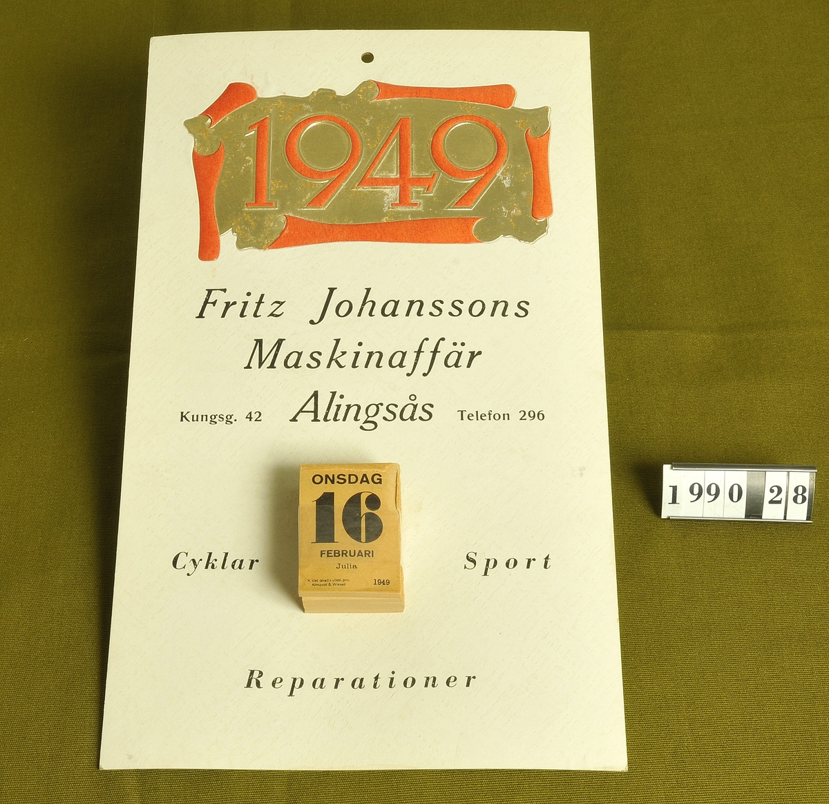 Vit papp med reklam för "Fritz Johanssons Maskin-
affär, Kungsgatn 42, Alingsås Tel: 296 
Cyklar Sport Reparationer".


Årtalet 1949 i rött och guld på dess övre del.

Almanacksblad:: 16 februari 1949.
