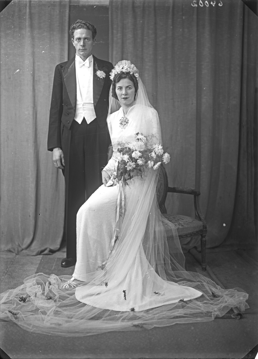 Portrett. Brudebilde. Ung kvinne i hvit brudekjole med slør og ung mann med mørk dress. Brudepar. Bestilt av Audun Kvale. Hordalandsgt.