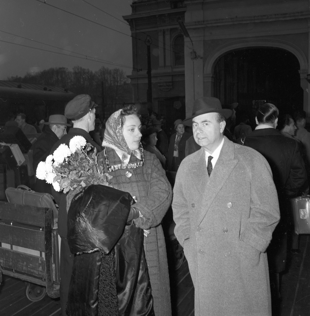 Kvinne og mann på togperrong, operasangere. Italiensk opera i Oslo. Fotografert 1958.
